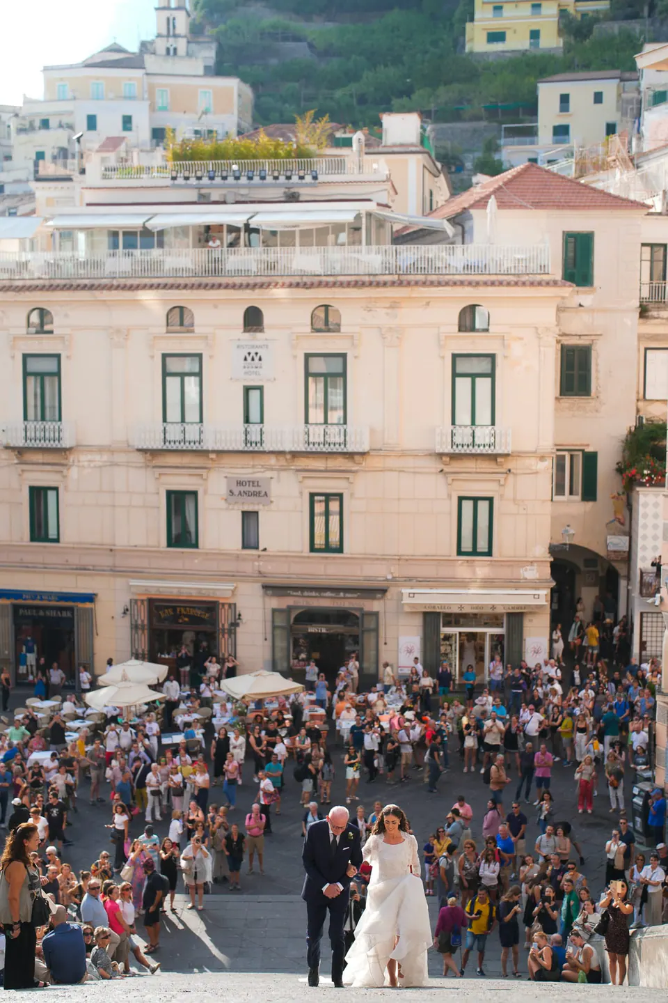 Bride and her father crossing the crowded Piazza Duomo in Amalfi toward the cathedral.