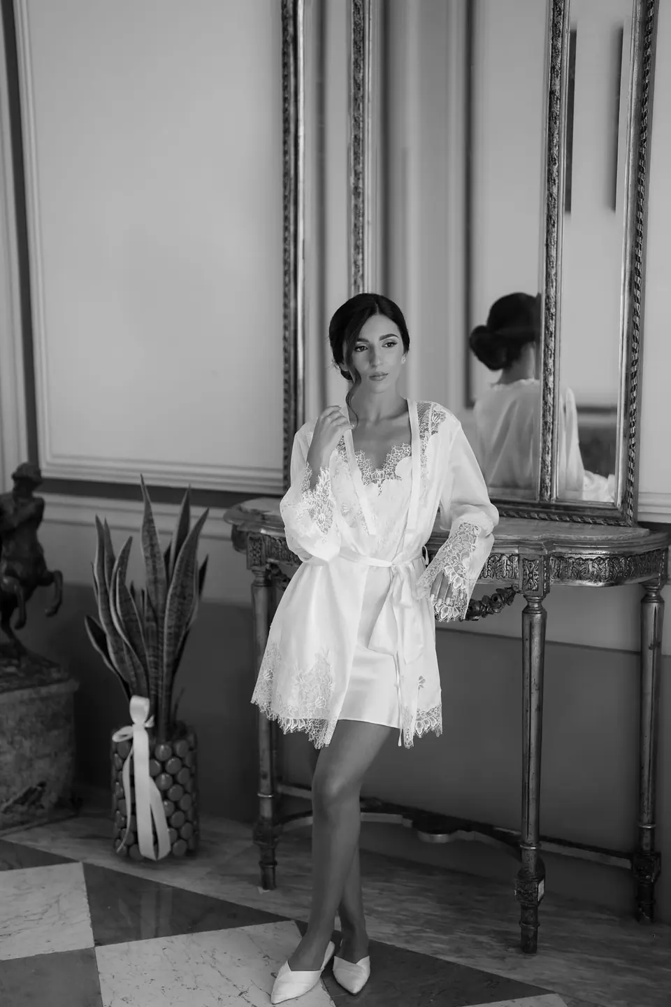 Black and white photo of the bride in her robe in a room