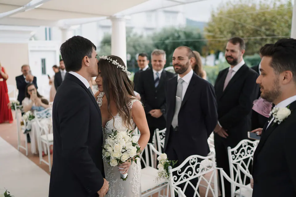 Bride and groom side by side among the guests at the ceremony.