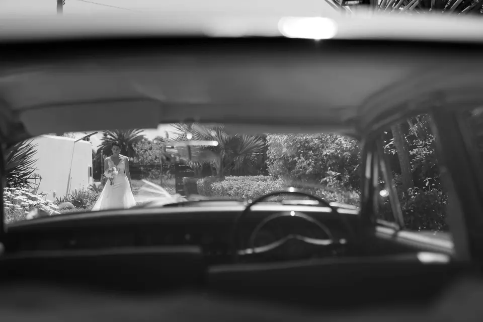 Black and white view through the windscreen of a vintage car on the wedding day