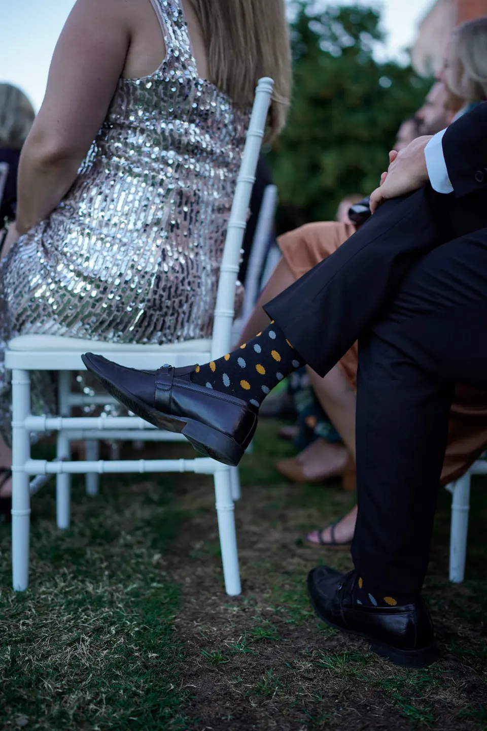 Guests seated during the ceremony, a sequinned dress in the foreground