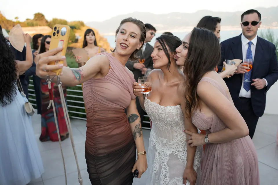 Die Braut macht auf der Terrasse ein Selfie mit ihren Freundinnen.