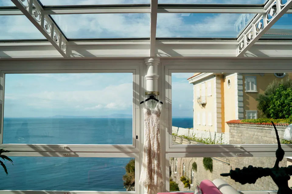 Glass-roofed room of Hotel Corallo with sea views, set for the ceremony.