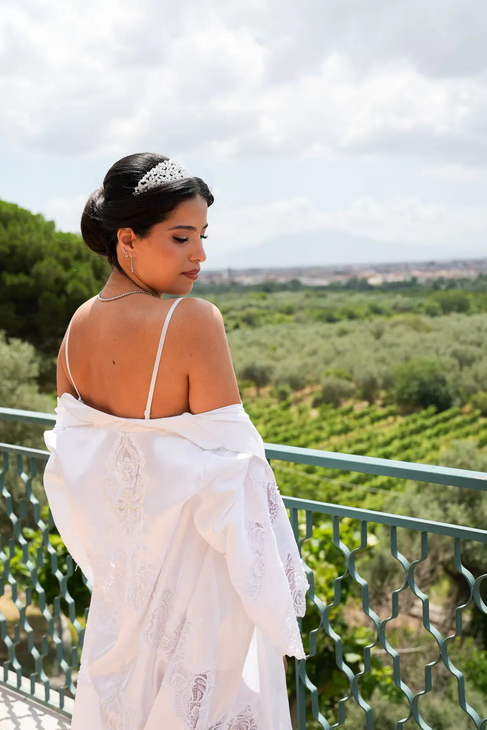 La mariée sur le balcon, le peignoir glissant de ses épaules, les vignes et les collines de Campanie derrière elle.