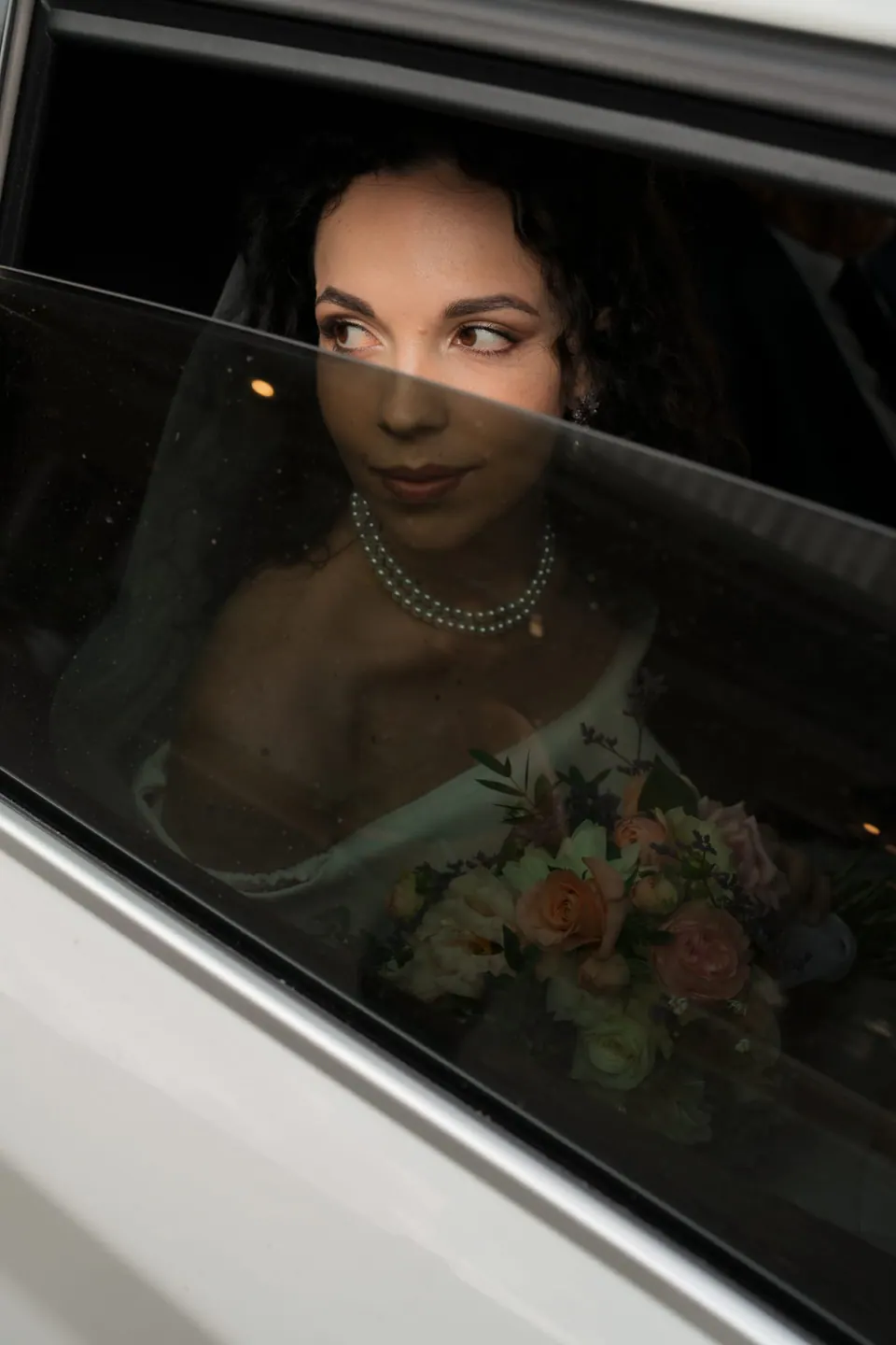 La cara de la novia reflejada en la ventanilla del coche antes de salir hacia la ceremonia.