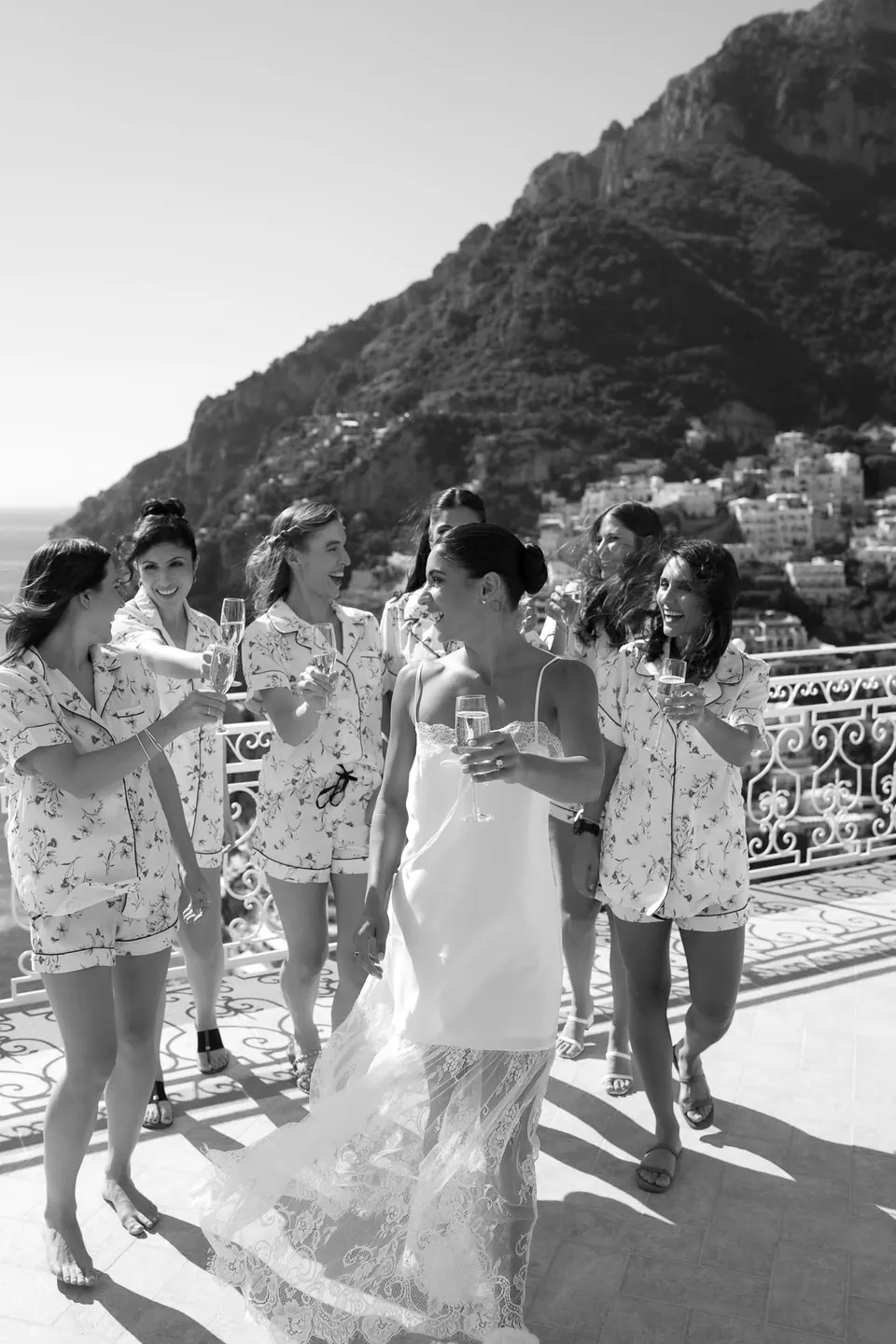 Black and white photo of the bride walking with her bridesmaids on the terrace.