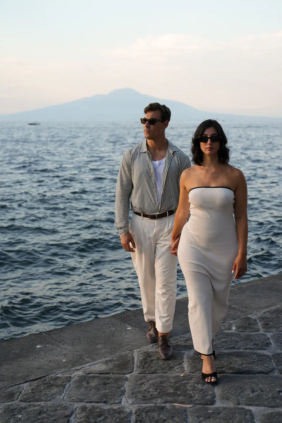Couple walking by the sea at the end of the day.