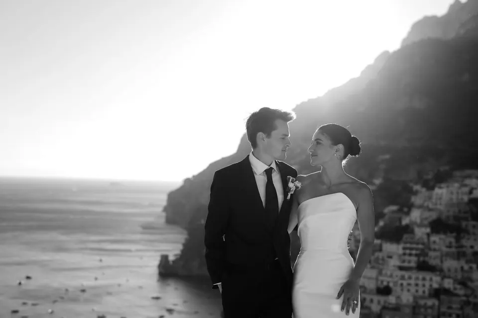 Black and white photo of the couple on the terrace, Positano behind them.