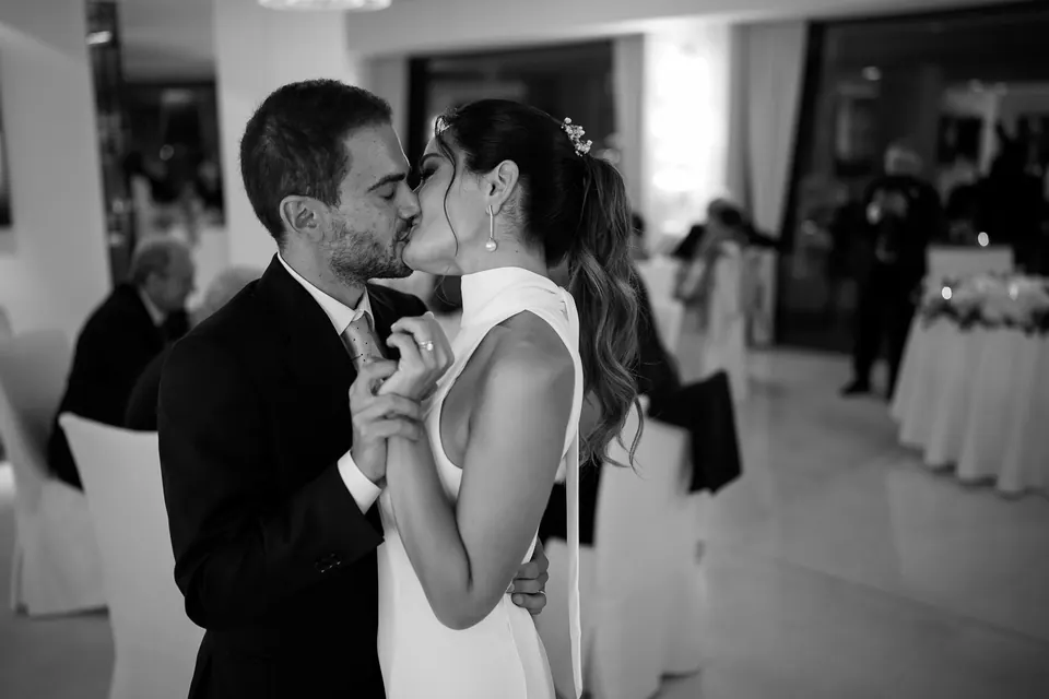Black and white photo of the couple embracing in the reception hall.