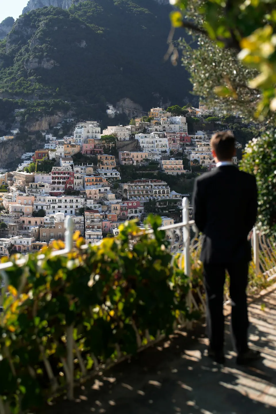 Groom seen from behind on the terrace, looking out at Positano.