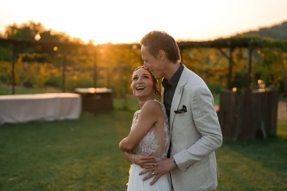 Bride and groom embracing at sunset