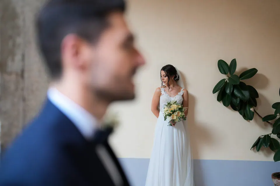Groom smiling as he watches the bride walk toward him, heartfelt reaction filled with love.