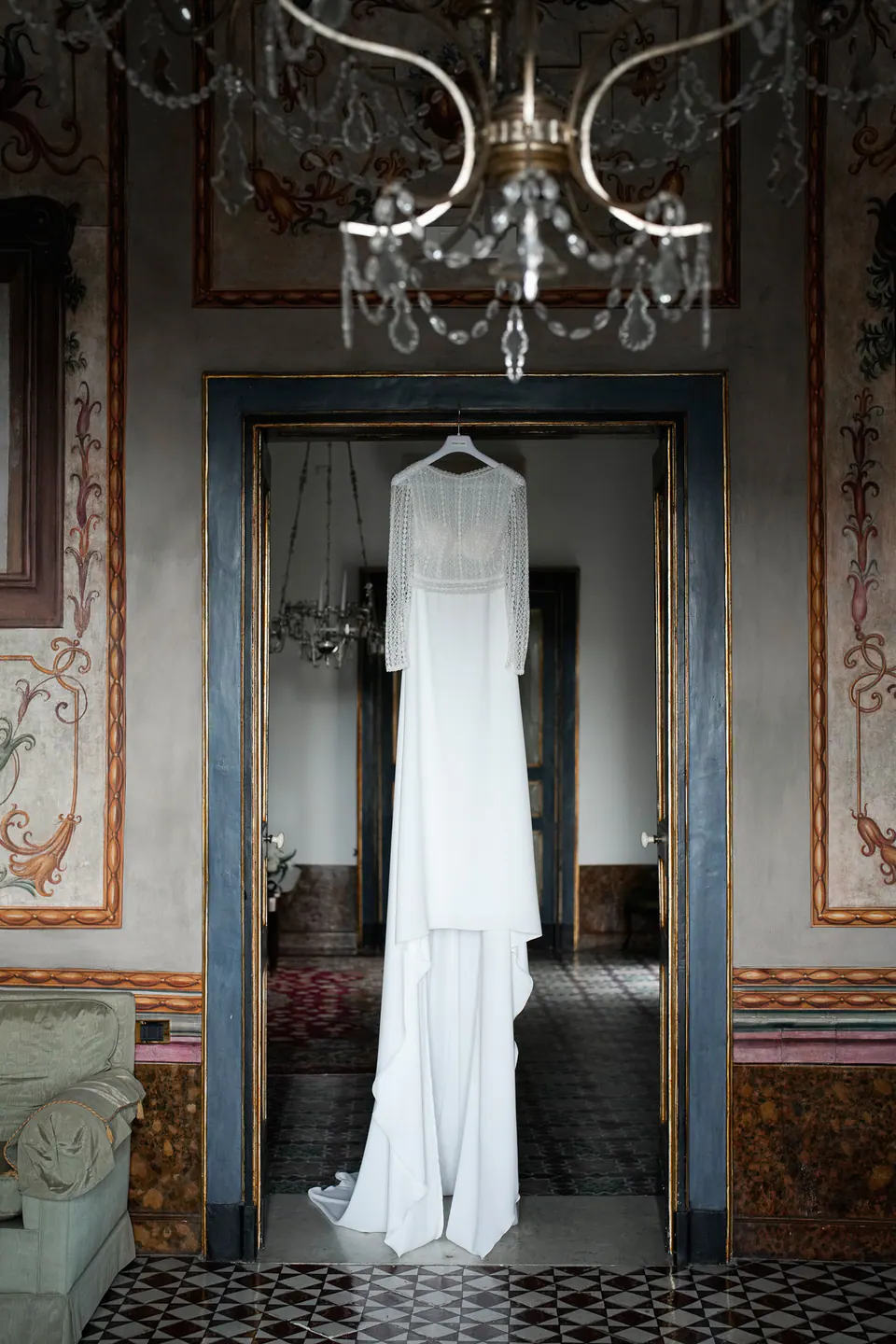 Wedding dress hanging in a room with gilded decorations.