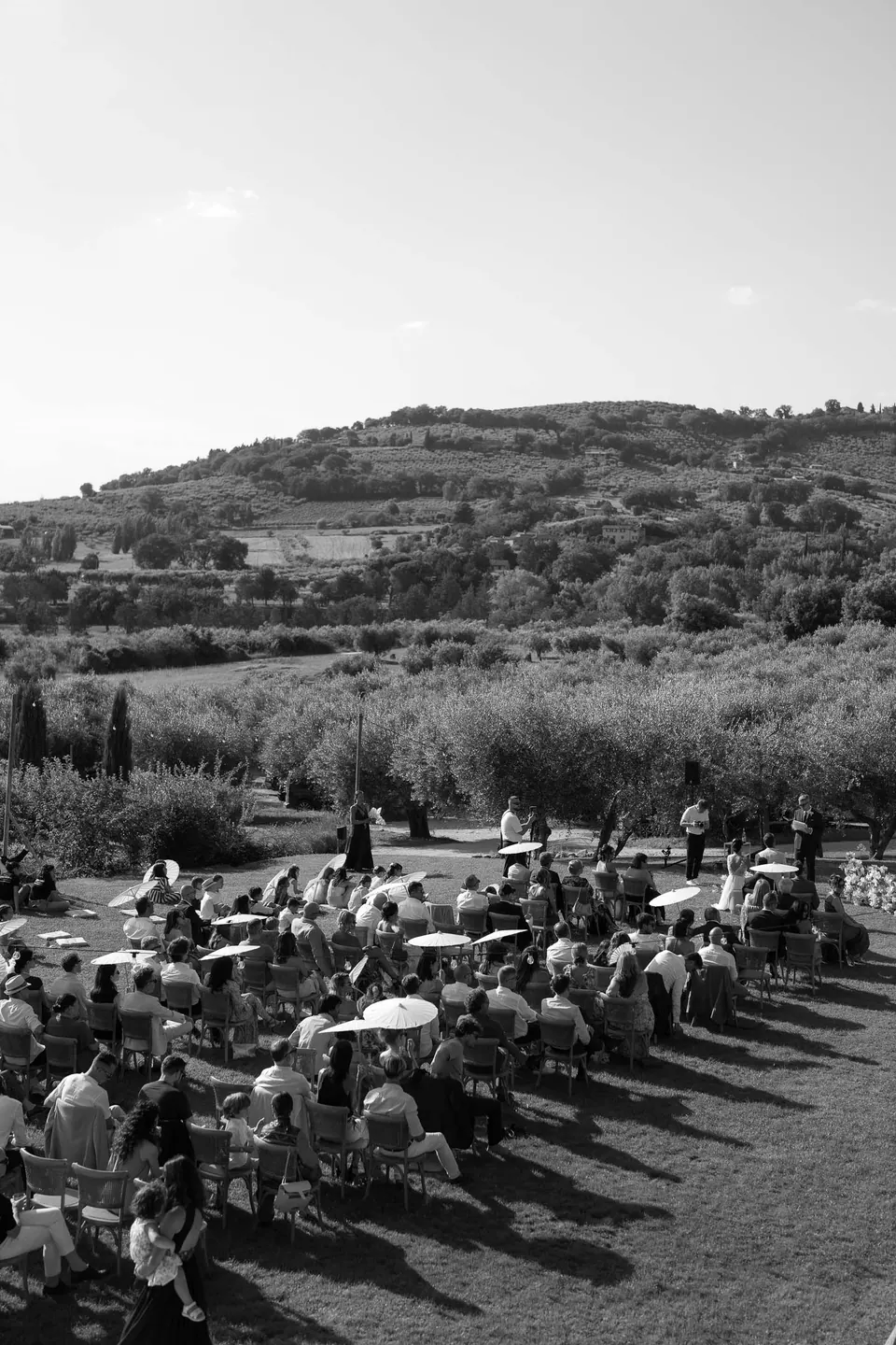 Black and white photo of the ceremony on the lawn seen from above, the hills beyond