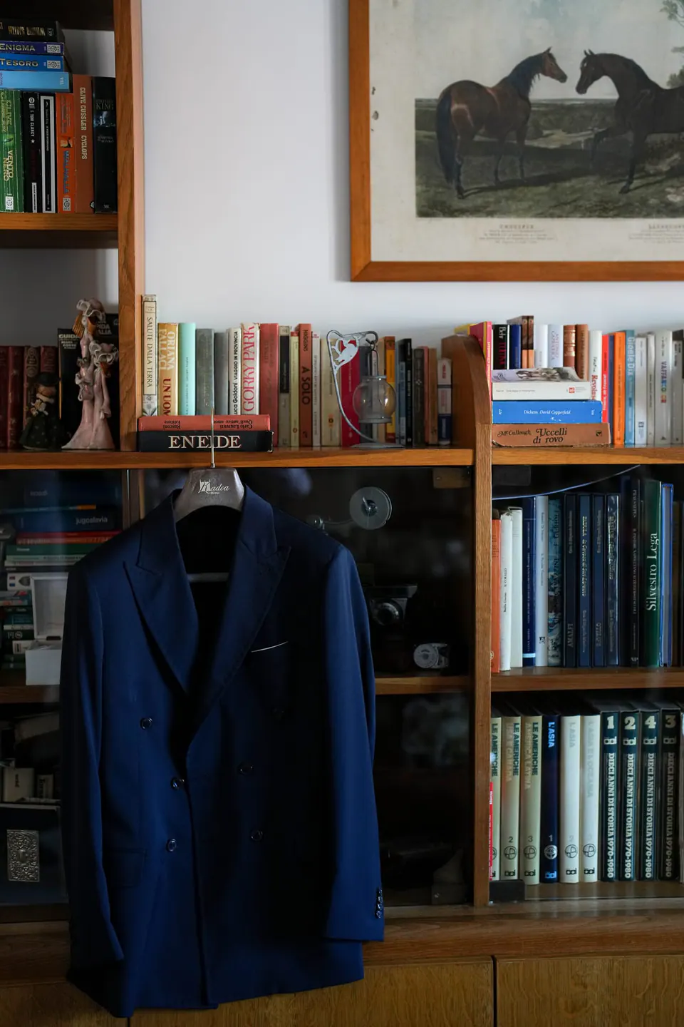 The groom's blue jacket hanging on a bookcase