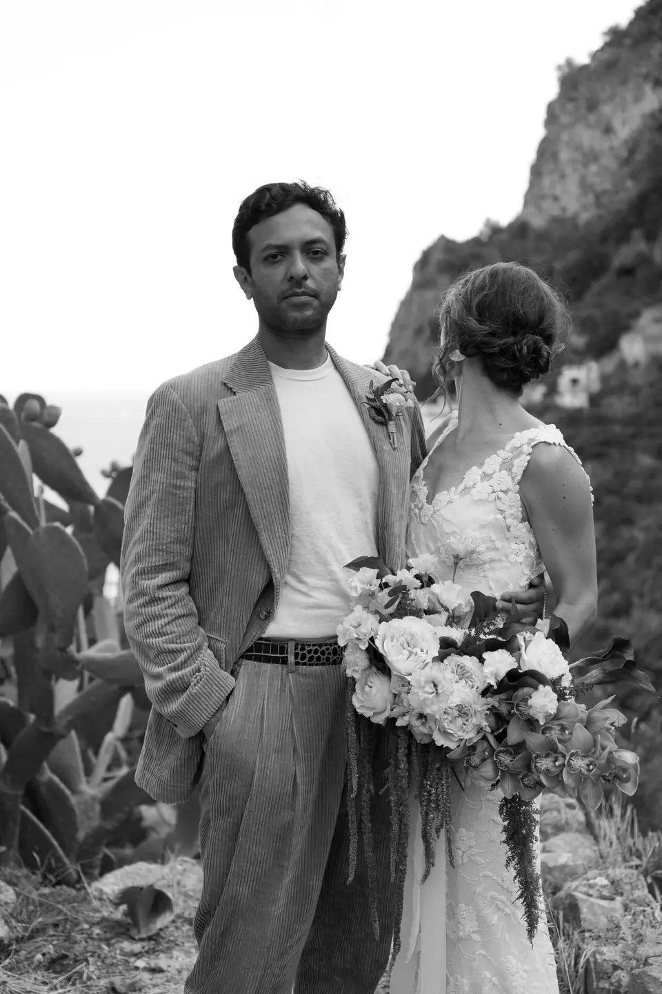 Black and white portrait of the couple among the cliffs of the coast.