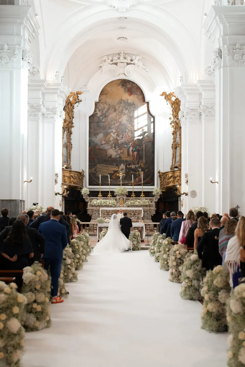 Bride walking down the flower-lined aisle of the church