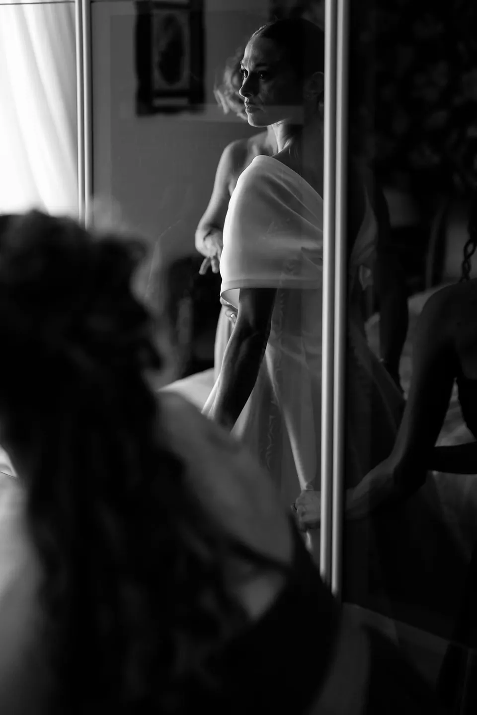 Black and white photo of the bride's reflection in a mirror during getting ready.