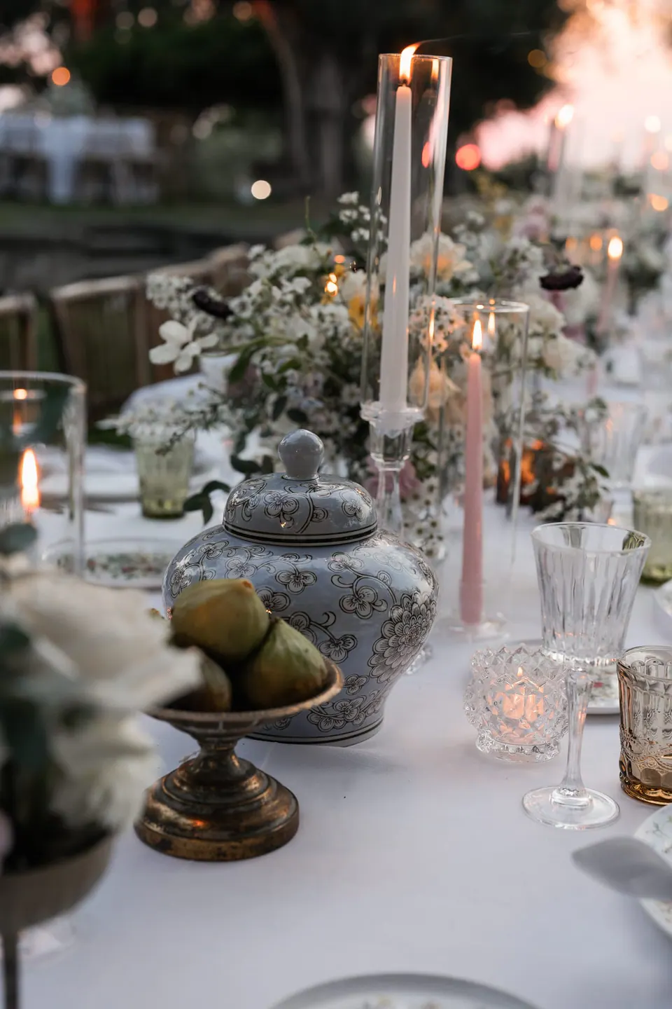 Dinner table with candles, crystal glasses and soft flowers.