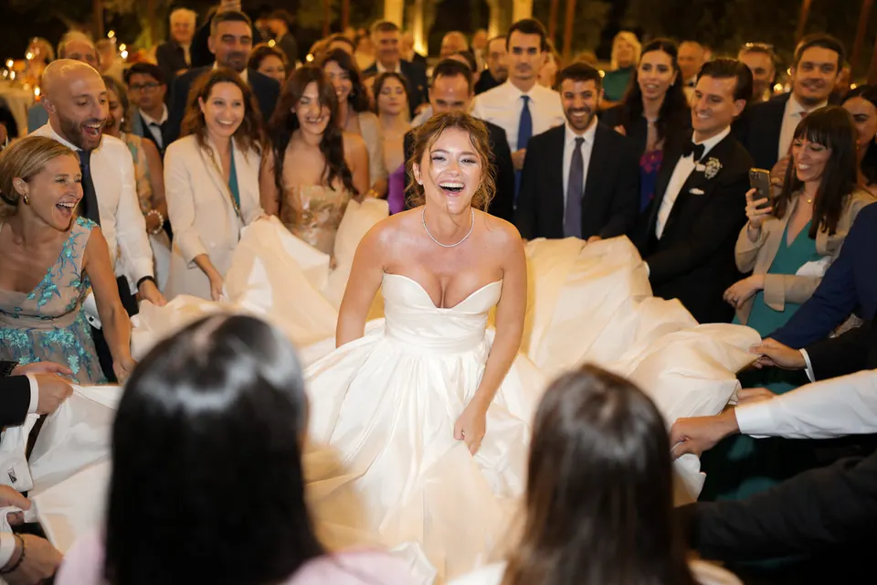 Sposa che ride in pista da ballo circondata dagli invitati.