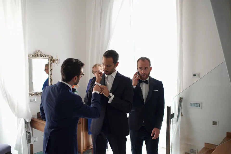 Groom talking with his friends before the ceremony, candid moment of camaraderie.