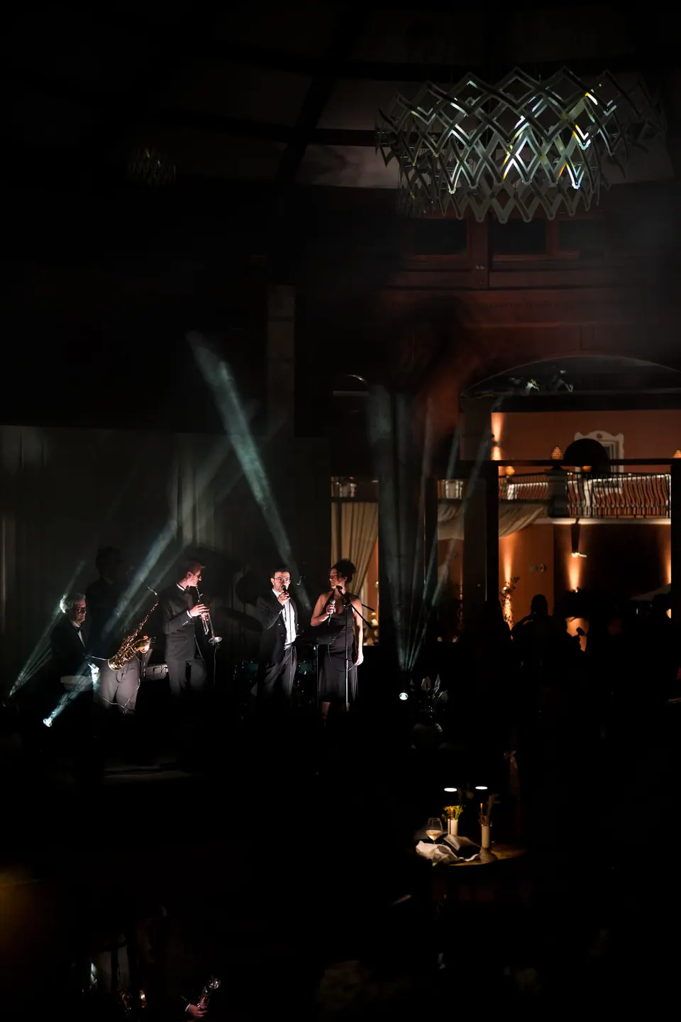 La banda en el escenario a oscuras bajo luces de colores.