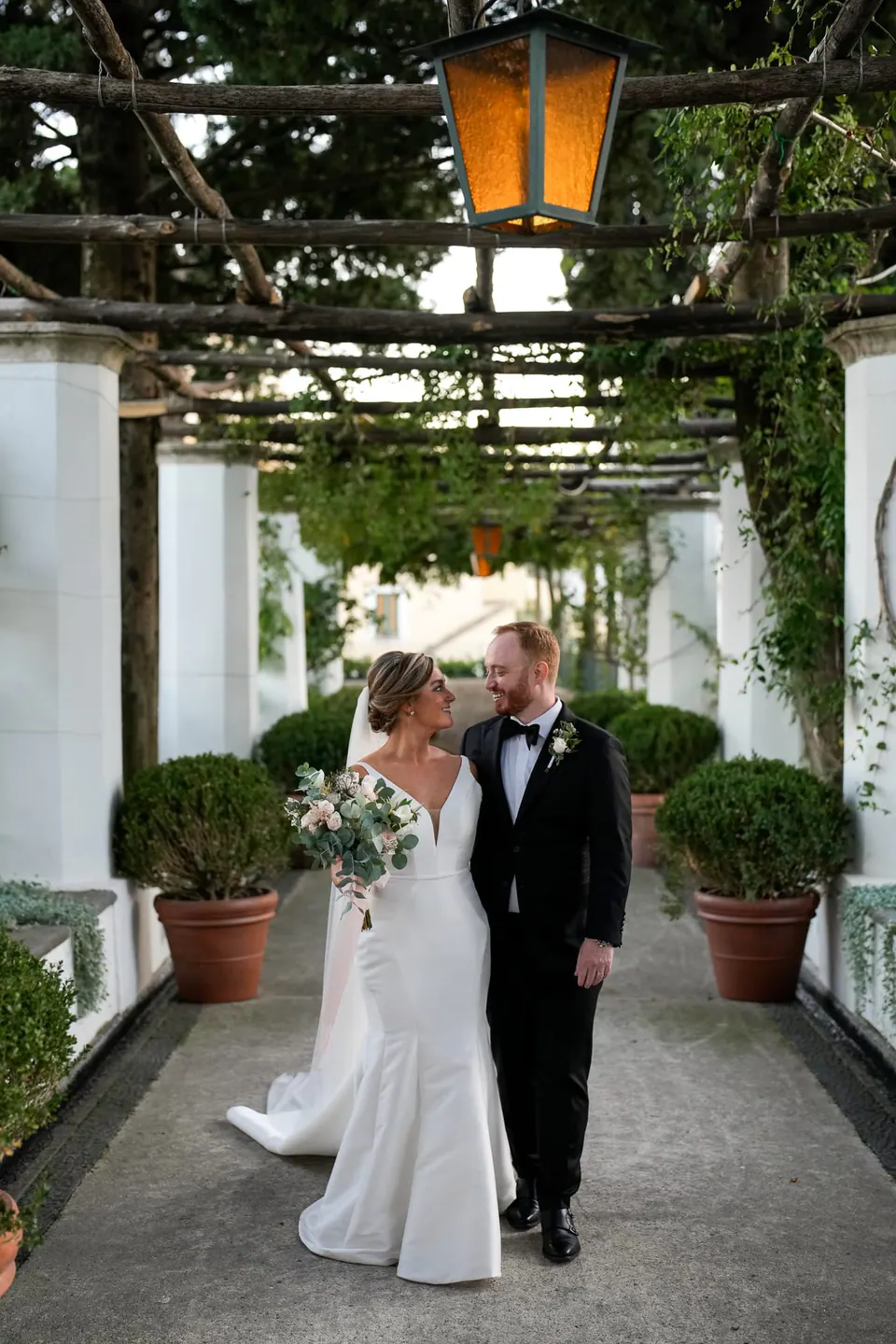 Bride and groom walking under the pergola