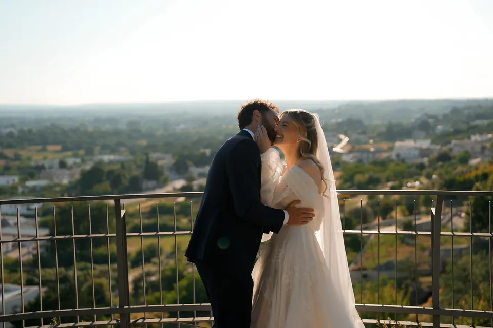 Los novios se besan frente al campo, retrato de boda en Italia.