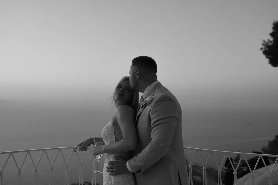 Bride and groom embracing at dusk, in silhouette against the last light on the Amalfi Coast.