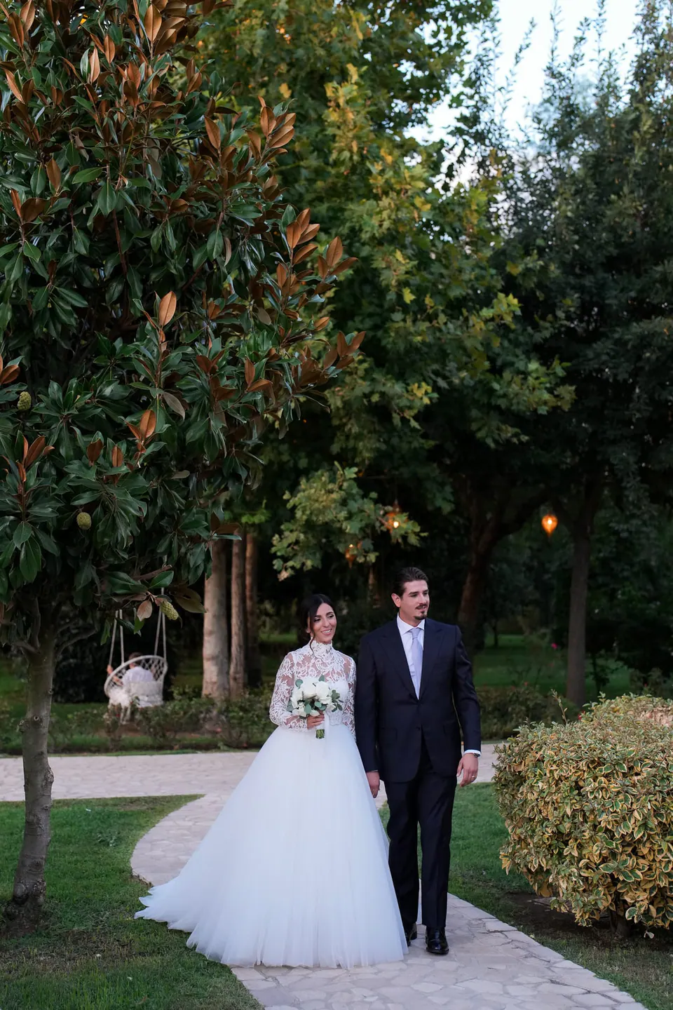 Bride and groom walking among the greenery of the villa gardens in Caserta.