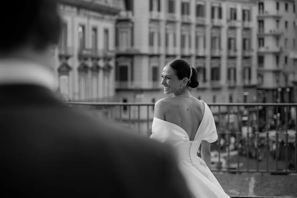 Foto in bianco e nero della sposa su un balcone affacciato sulle strade di Napoli.