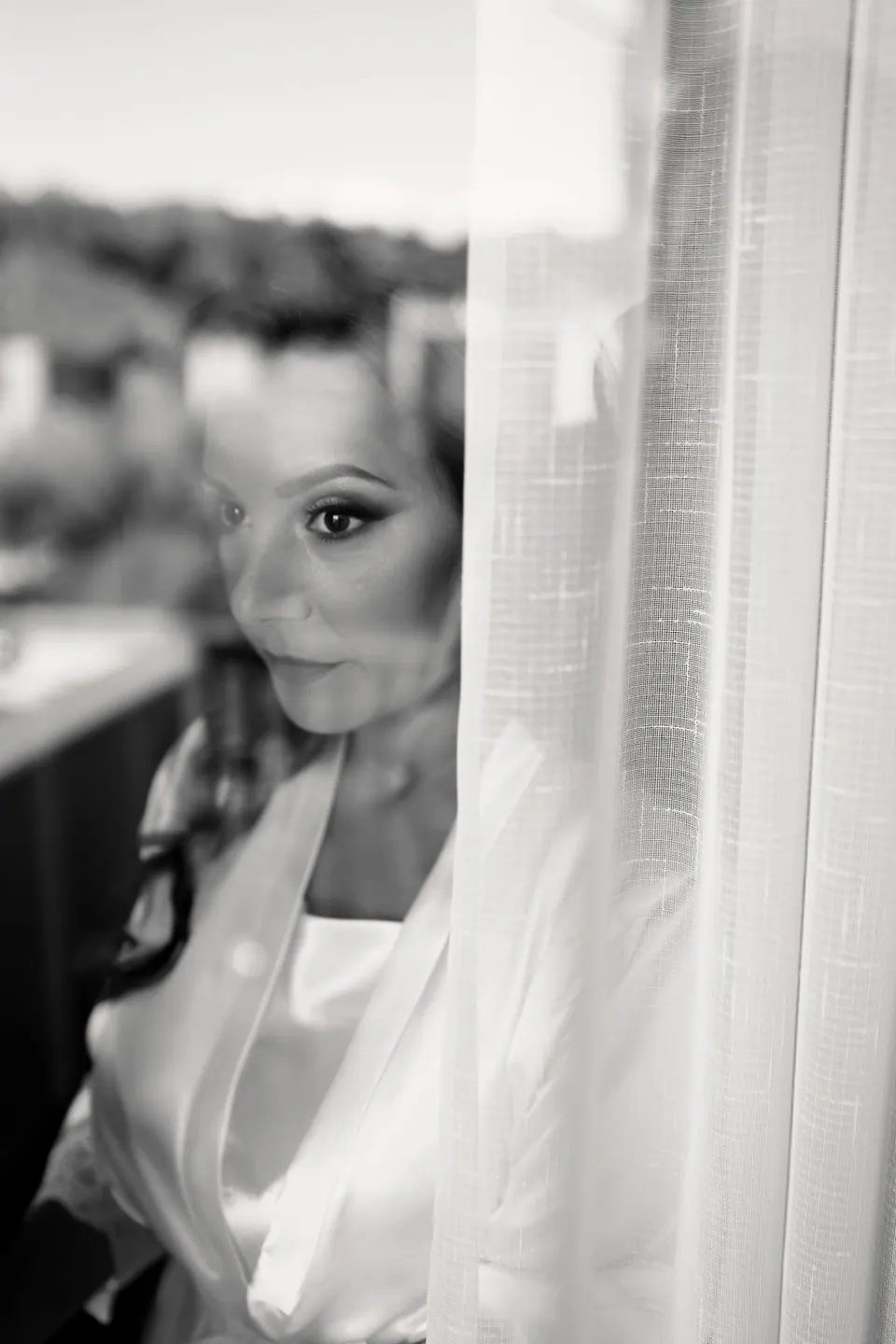 The bride's reflection in the window as she gets ready.