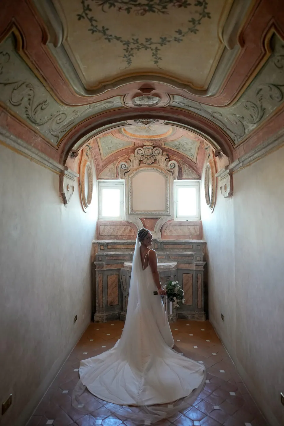 Bride standing alone in a frescoed room at the Belmond Hotel Caruso, Ravello