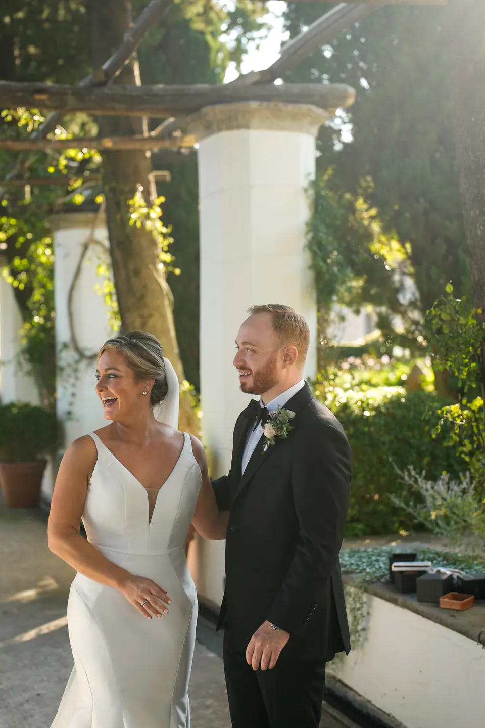 Bride and groom smiling under the pergola