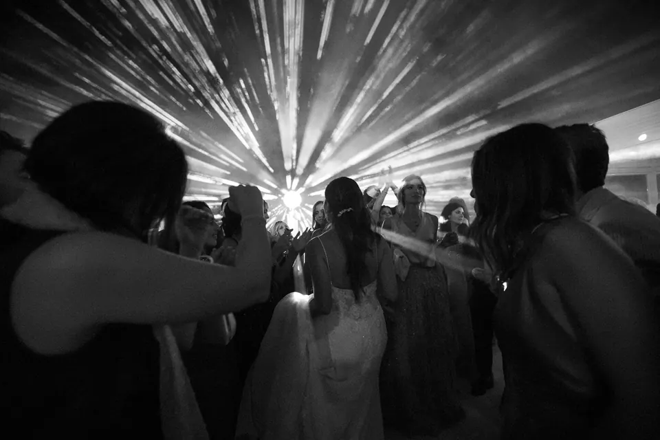 Foto in bianco e nero della pista da ballo sotto i fasci di luce.