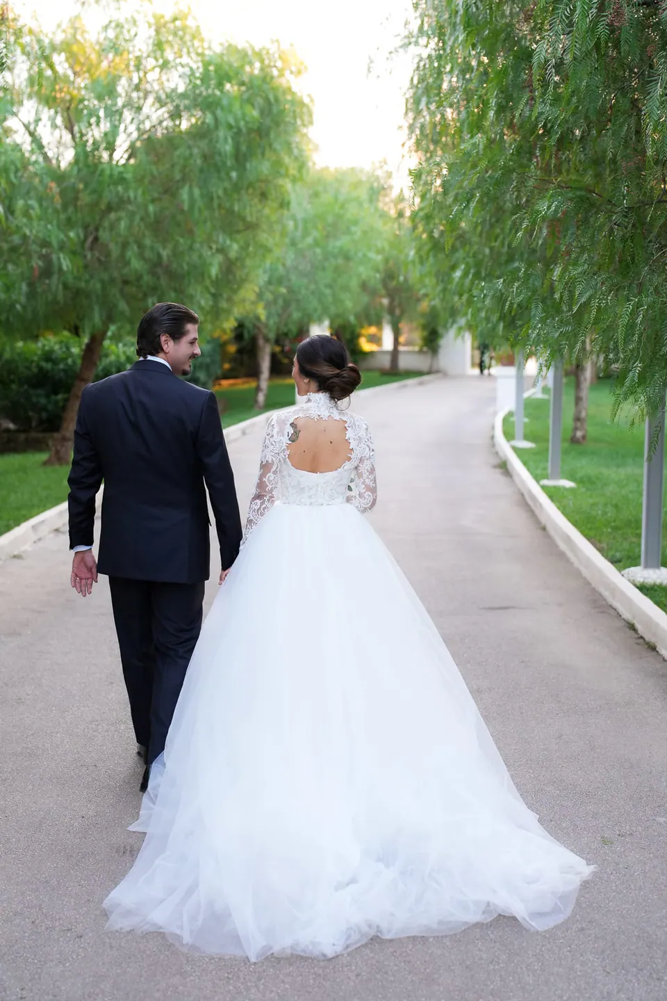 Bride and groom walking hand in hand through the gardens of Tenuta San Domenico.