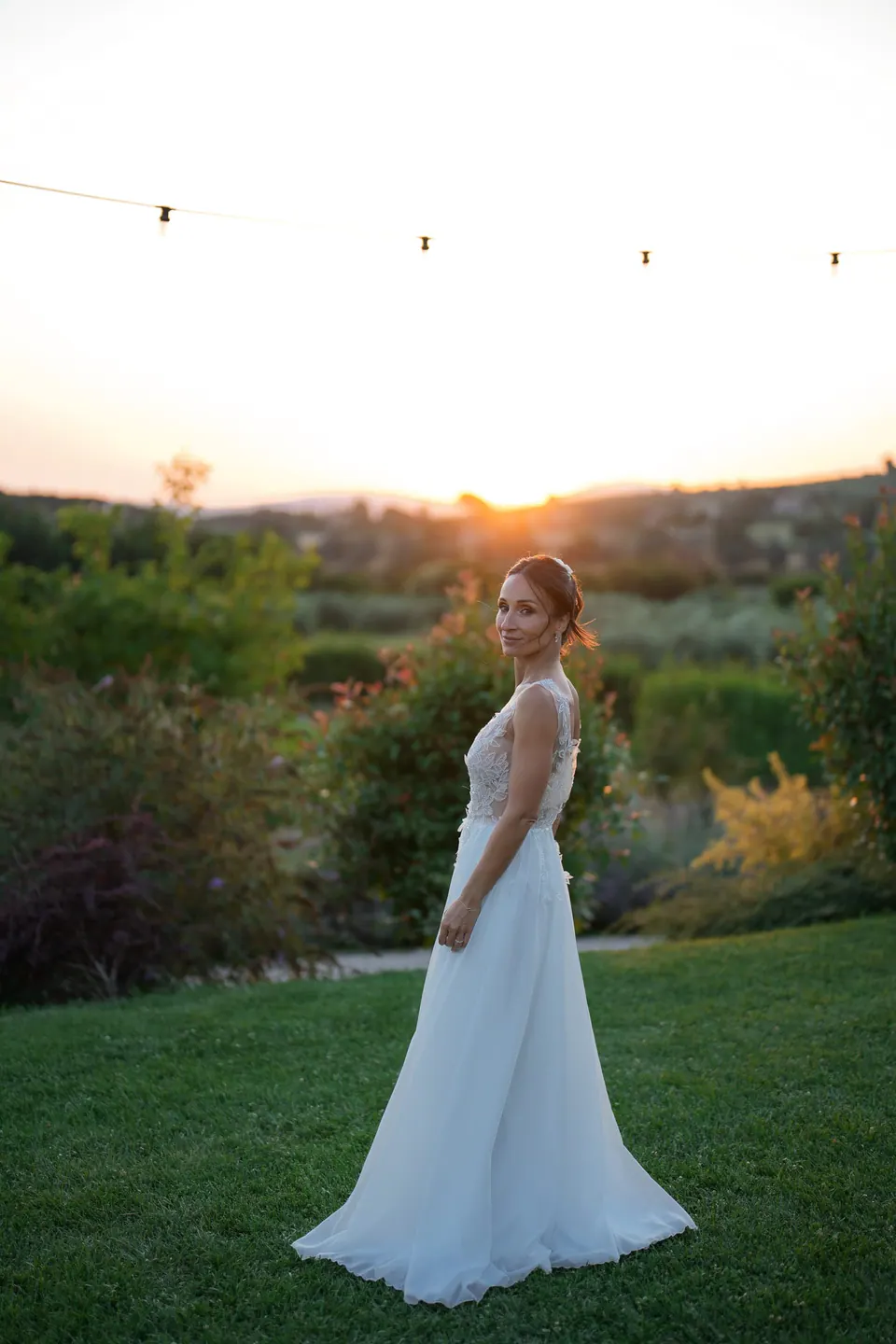Bride walking alone at sunset in the Umbrian countryside.