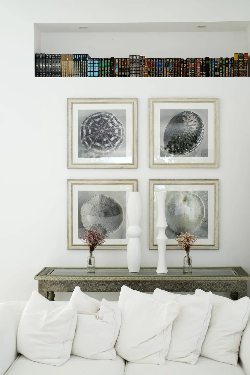 White sofa and framed botanical prints in the bright groom's suite.