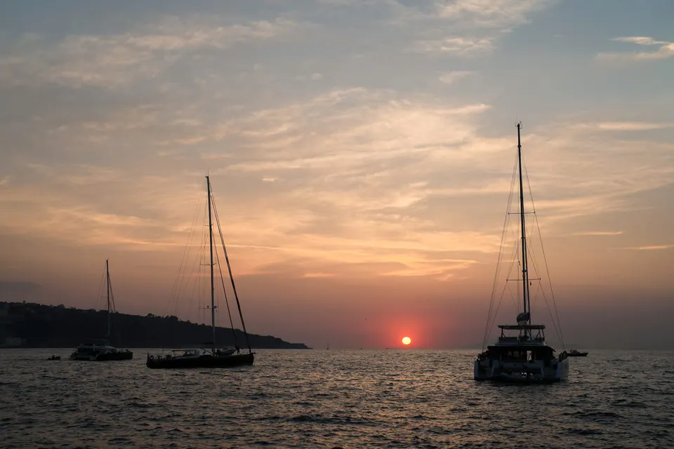 Roter Sonnenuntergang über den Segelbooten in der Bucht von Sorrent.
