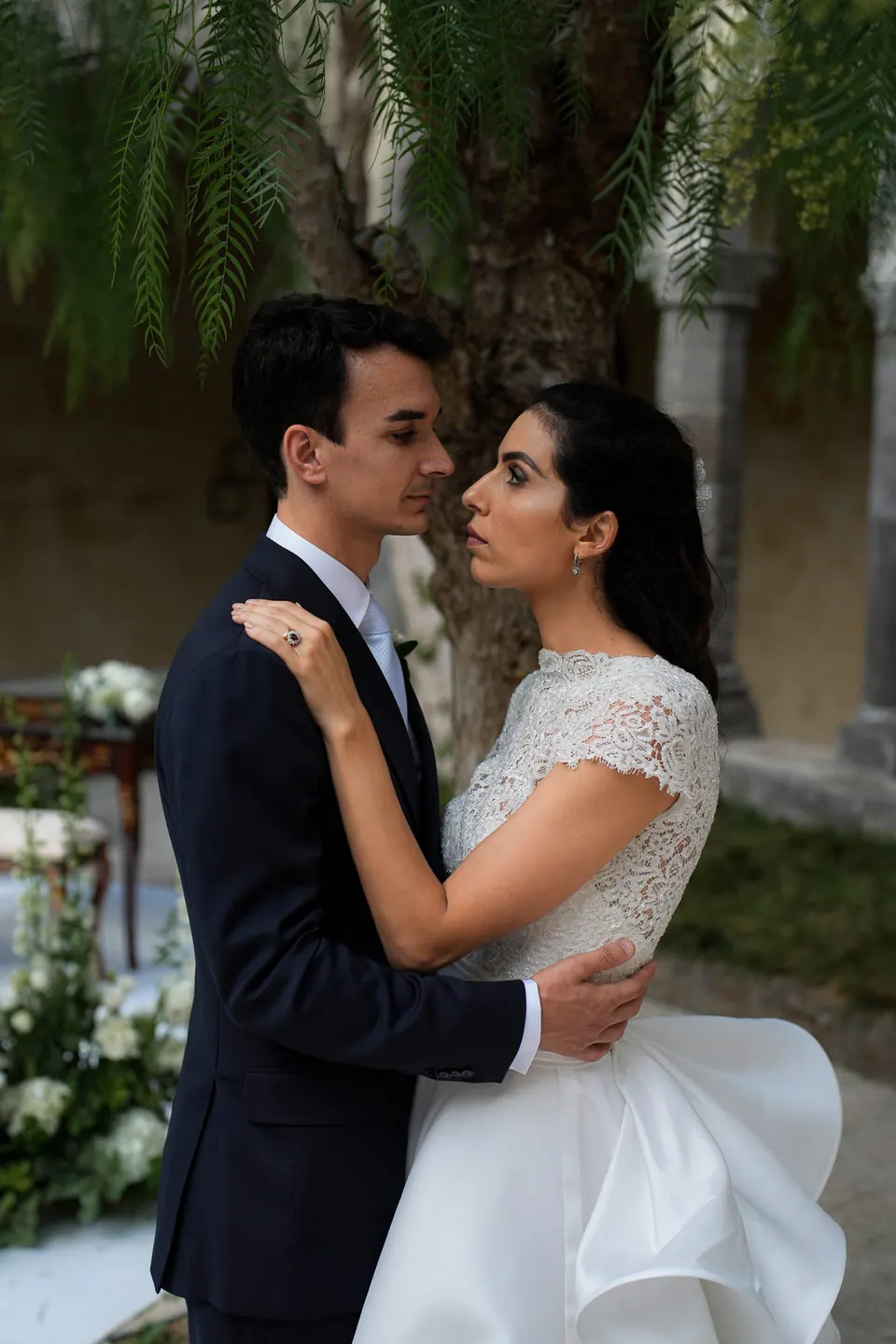 Bride and groom embracing in the cloister garden