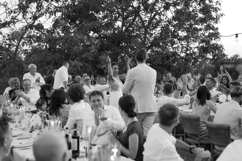 Black and white photo of guests cheering at dinner