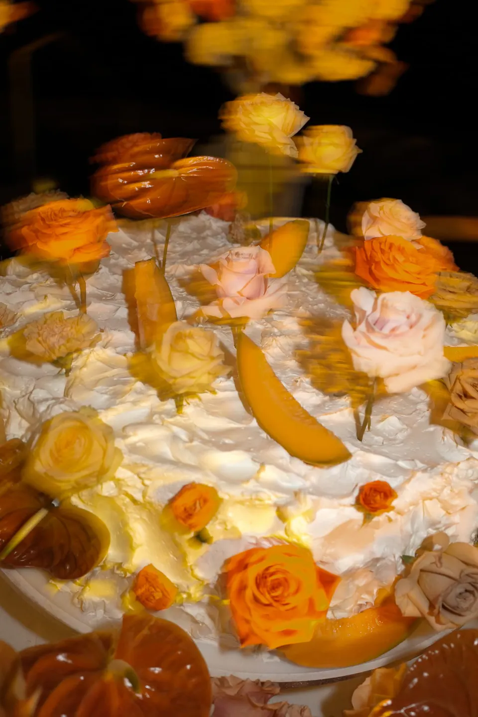 Detail der Hochzeitstorte mit orangen und pfirsichfarbenen Rosen.
