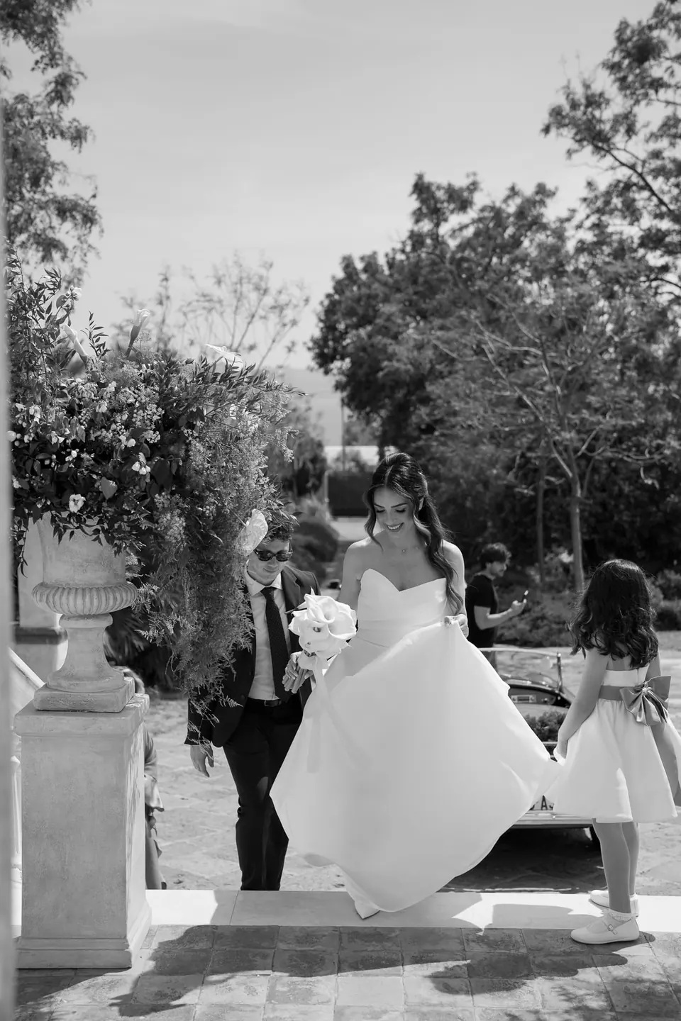 Foto en blanco y negro de la novia caminando por el jardín.