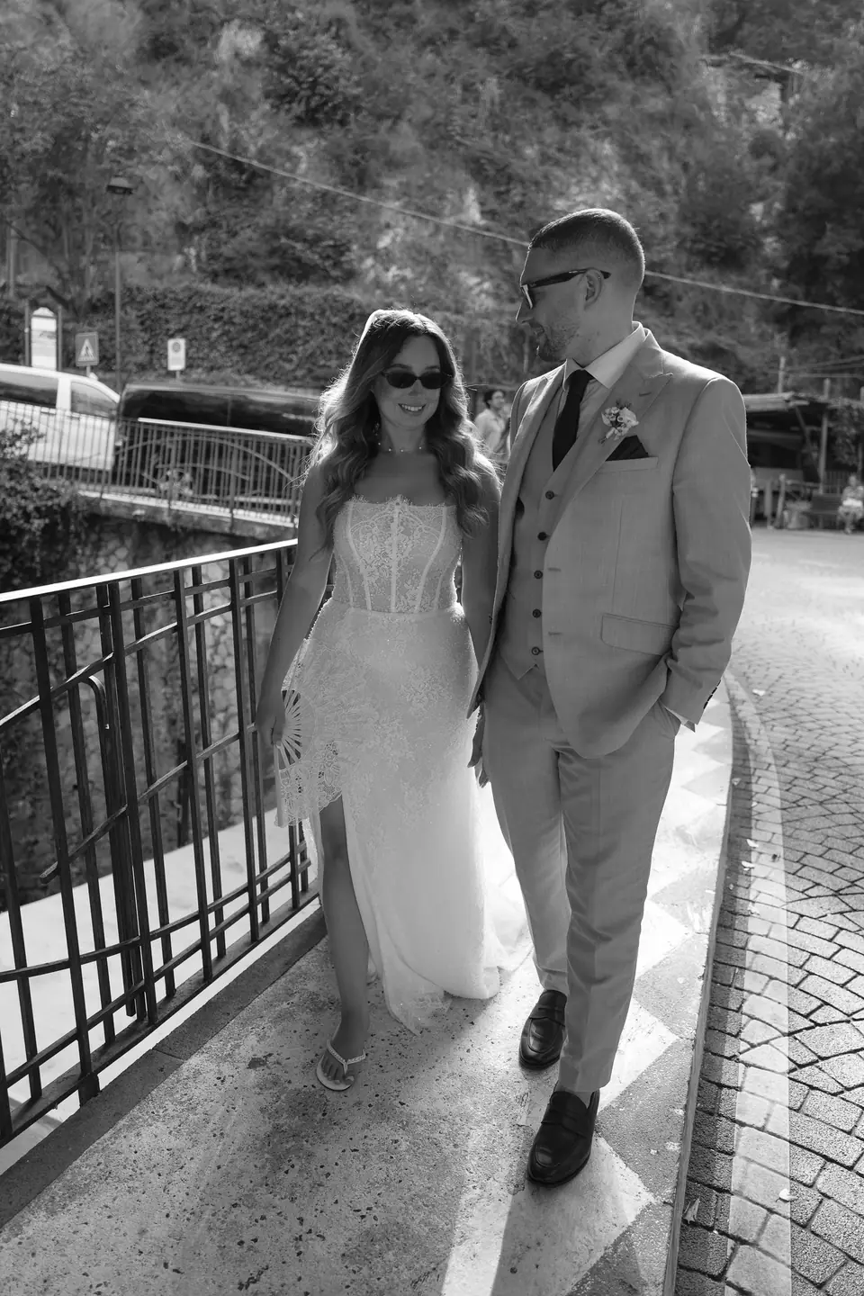 Black and white photo of the couple walking along a street in Positano.
