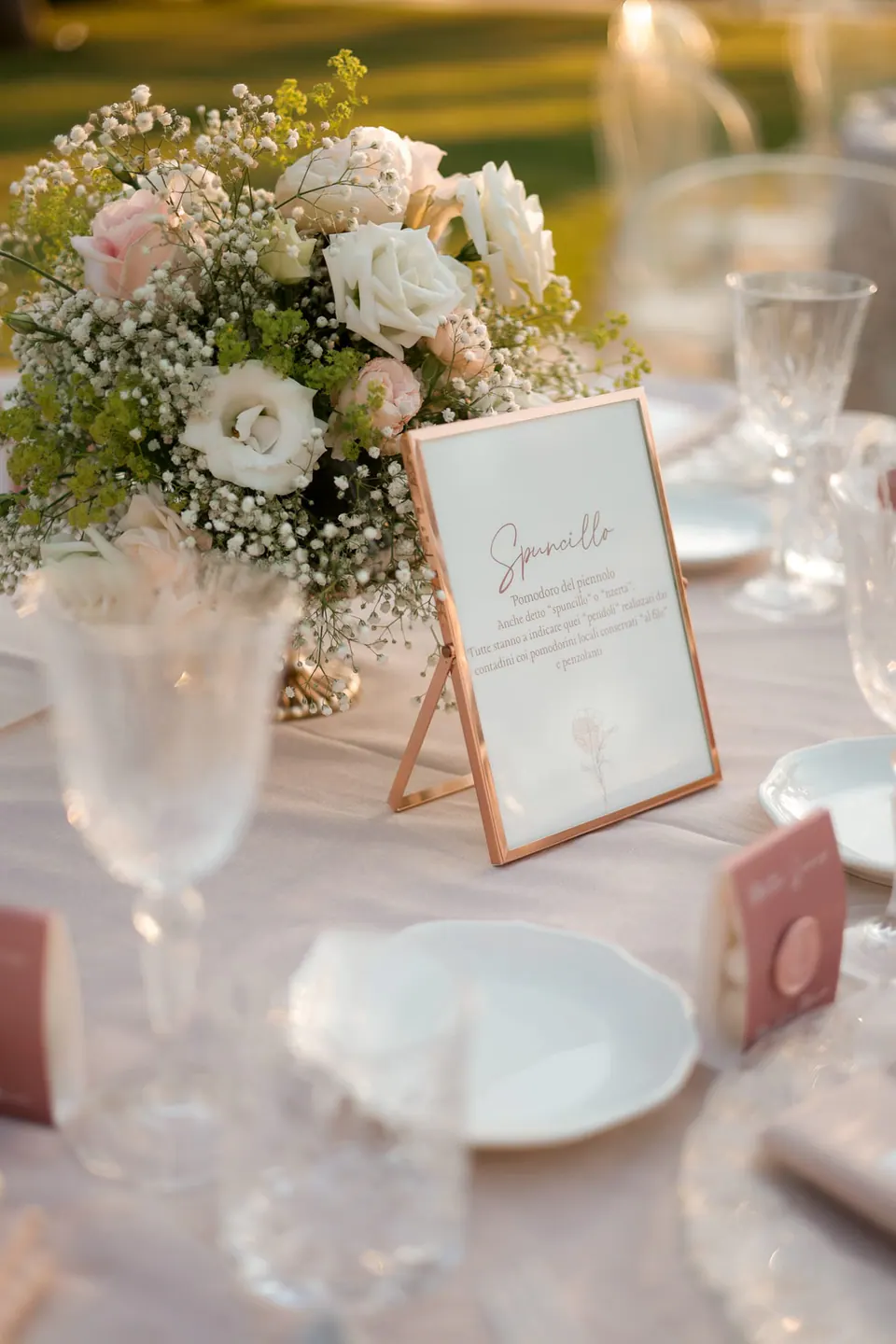 Table detail with pale roses and a handwritten table card