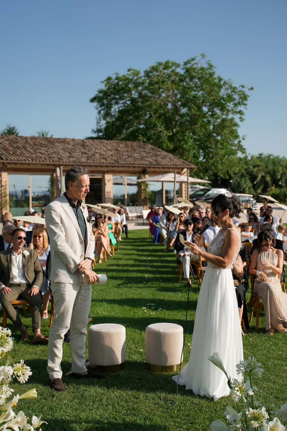 Bride and groom facing each other at the ceremony on the lawn