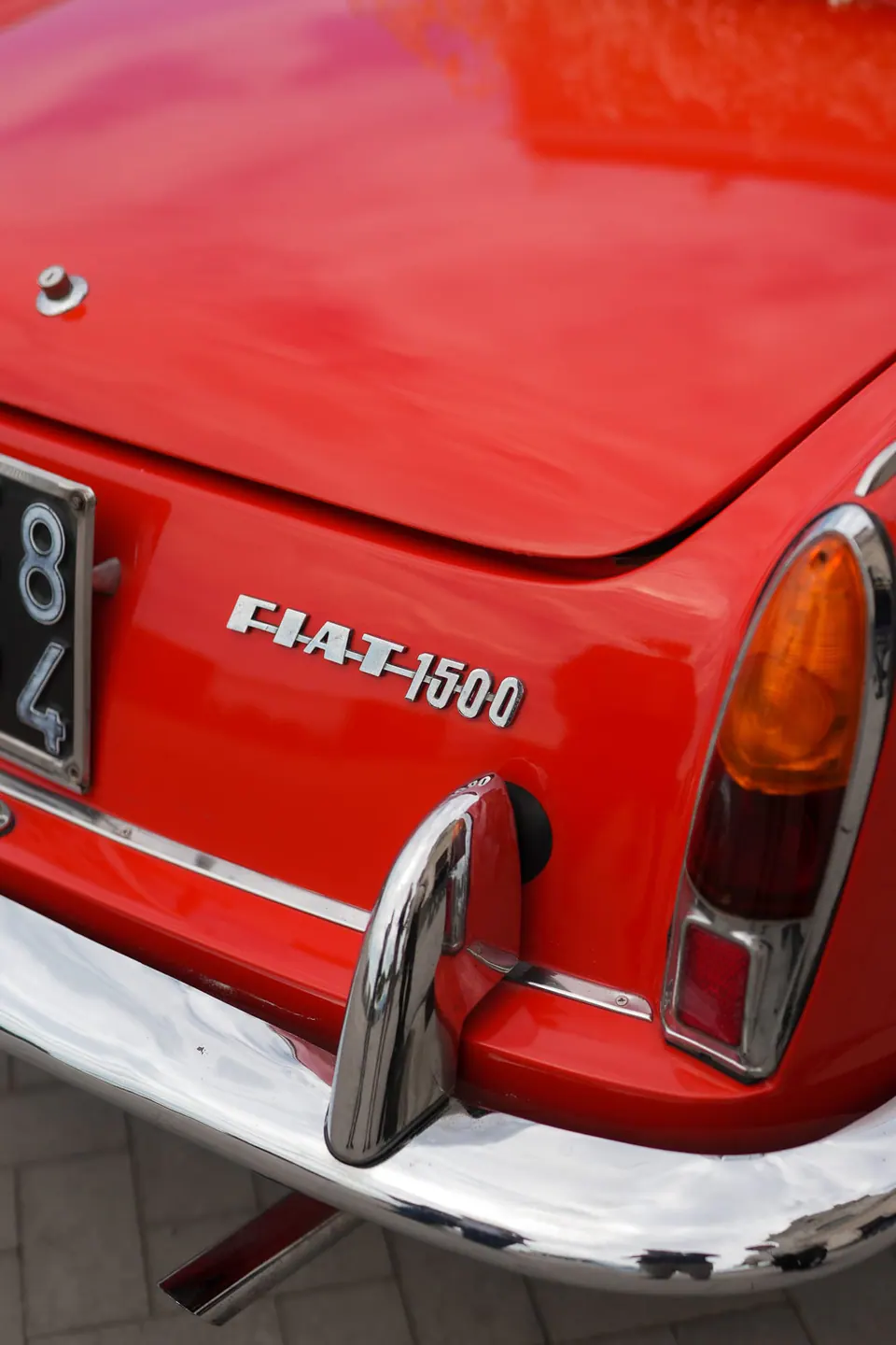 Rear badge of a red vintage Fiat 1500 convertible, the wedding car.
