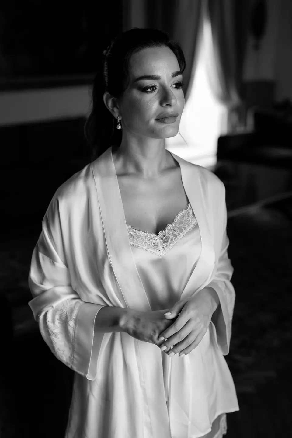 Bride in silk robe, serene and reflective morning moment before getting dressed.