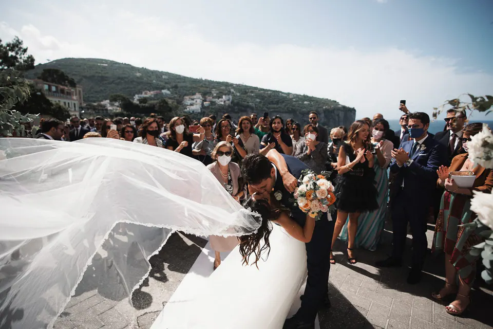 Il velo della sposa sollevato dal vento davanti al Castello Giusso, momento cinematografico di un matrimonio italiano.