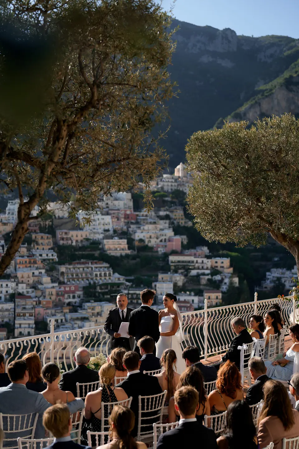 Guests at the ceremony seen from above, the town of Positano beyond.
